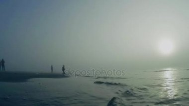Sisin içinde dalgalar deniz. Güneş ışığında deniz kenarı sis yamalari ile sıçramasına dalgalar deniz. 