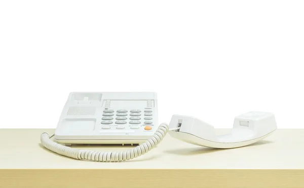 Telefono bianco primo piano, telefono ufficio su scrivania in legno sfocato nella sala riunioni sotto la luce della finestra isolato su sfondo bianco — Foto Stock