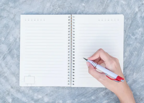 Primer plano de la mujer escritura a mano en el libro de notas en el escritorio de hormigón en el fondo texturizado vista superior bajo la luz del día en el jardín — Foto de Stock