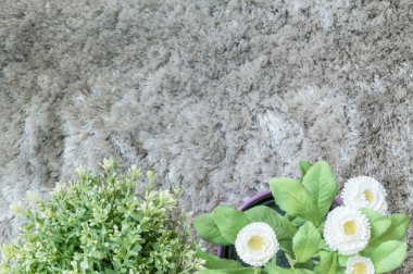 Üst görünümünde bulanık gri halı dokulu arka plan üzerinde saksı beyaz çiçek ile Closeup yapay bitki