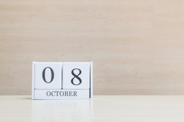 Pencere ışığı altında kopya alanı ile bulanık kahverengi ahşap masa ve ahşap duvar dokulu arka plan siyah 8 ekim kelime ile closeup yüzey beyaz ahşap takvim