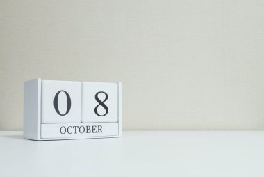Fotokopi alanı ile oda dokulu arka plan bulanık beyaz ahşap masa ve krem renkli duvar kağıdı siyah 8 ekim kelime ile closeup yüzey beyaz ahşap takvim