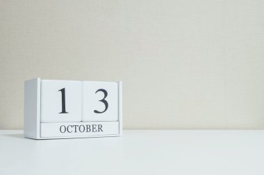 Kopya alanı ile oda dokulu arka plan bulanık beyaz ahşap masa ve krem rengi duvar kağıdı siyah 13 ekim kelime ile Closeup beyaz ahşap takvim , portföyümde başka bir tarih görünümü