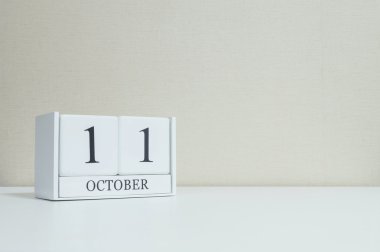 Kopya alanı ile oda dokulu arka plan bulanık beyaz ahşap masa ve krem rengi duvar kağıdı siyah 11 ekim kelime ile Closeup beyaz ahşap takvim , portföyümde başka bir tarih görünümü