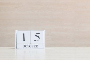 Kapalı yüzey beyaz ahşap takvim, siyah 15 Ekim 'de kahverengi ahşap masa ve ahşap duvar, arka planda fotokopi alanı ile dokuma, portföyümde bir tarih daha göster