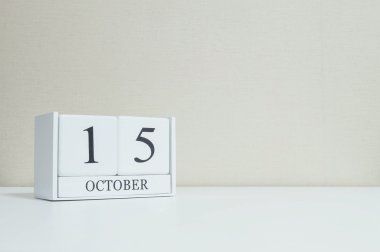 Bulanık Beyaz ahşap masa ve krem renk duvar kağıdı ile kopya alanı, Oda dokulu arka plan üzerinde siyah 15 Ekim Word'le closeup Beyaz ahşap takvimi görüntüleme başka daha fazla tarihi benim portföy