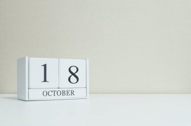 Bulanık Beyaz ahşap masa ve krem renk duvar kağıdı ile kopya alanı, Oda dokulu arka plan üzerinde siyah 18 Ekim Word'le closeup Beyaz ahşap takvimi görüntüleme başka daha fazla tarihi benim portföy