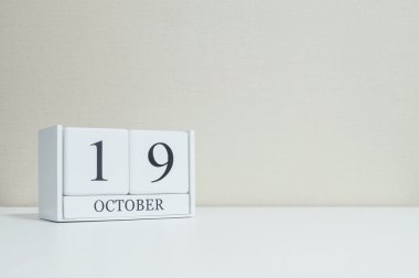 Bulanık Beyaz ahşap masa ve krem renk duvar kağıdı ile kopya alanı, Oda dokulu arka plan üzerinde siyah 19 Ekim Word'le closeup Beyaz ahşap takvimi görüntüleme başka daha fazla tarihi benim portföy