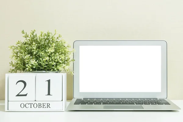 Calendario de madera blanca con negro 21 palabra de octubre con espacio en blanco en el centro de la computadora portátil en escritorio de madera blanca y fondo de pantalla crema texturizado, enfoque selectivo en el calendario — Foto de Stock