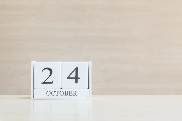 Primer plano de la superficie del calendario de madera blanca con negro 24 palabra de octubre en borrosa escritorio de madera marrón y fondo texturizado pared de madera con espacio de copia, enfoque selectivo en el calendario — Foto de Stock