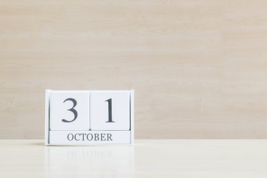 Closeup bulanık kahverengi ahşap masa ve kopya alanı, takvim, seçici odak ile ahşap duvar dokulu arka plan üzerinde siyah 31 Ekim kelime ile beyaz ahşap takvim yüzey