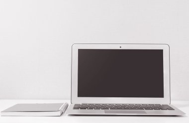 Closeup bilgisayar notebook bulanık Beyaz ahşap Resepsiyon ve krem renk duvar kağıdı duvar arka planda Oda doku, güzel iş yerinde iç siyah ve beyaz ses tonuyla evde kavramının
