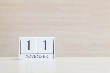 Closeup bulanık kahverengi ahşap masa ve kopya alanı, takvim, seçici odak ile ahşap duvar dokulu arka plan üzerinde siyah 11 Kasım kelime ile beyaz ahşap takvim yüzey