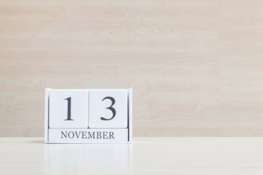 Closeup bulanık kahverengi ahşap masa ve kopya alanı, takvim, seçici odak ile ahşap duvar dokulu arka plan üzerinde siyah 13 Kasım kelime ile beyaz ahşap takvim yüzey