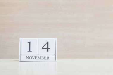 Closeup bulanık kahverengi ahşap masa ve kopya alanı, takvim, seçici odak ile ahşap duvar dokulu arka plan üzerinde siyah 14 Kasım kelime ile beyaz ahşap takvim yüzey