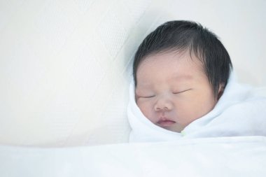 Yatakta rahat bir şekilde uyuyan bir bebeği yakından çek.