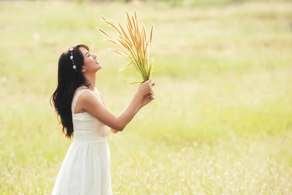Mladá šťastná žena bílé šaty s rukama chytit zelené zlato g — Stock fotografie