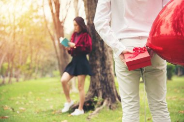 young happy asian couple surprise gift red box at public park