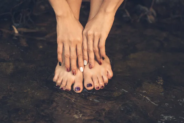 女性の手と足の指の芸術水に爪をペイント — ストック写真