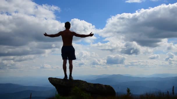 Άνθρωπος Στέκεται Στην Κορυφή Ενός Βουνού Ανοιχτά Χέρια — Αρχείο Βίντεο