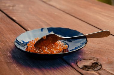 ahşap plakalar. mavi bir tabak içinde kırmızı havyar.