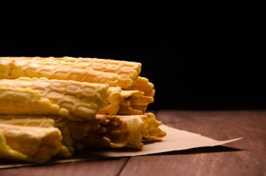 Tüp şeklinde gofret. Kraft kağıdında waffle. Tahta üzerinde waffle.
