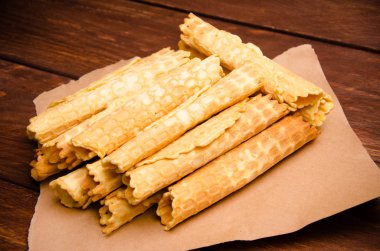 Tüp şeklinde gofret. Kraft kağıdında waffle. Tahta üzerinde waffle.
