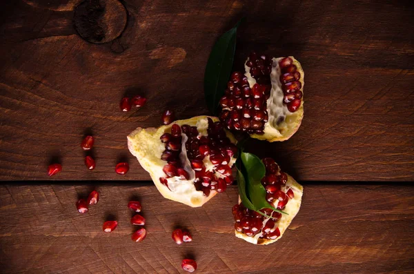 Der Granatapfel ist reif. in Stücke von reifen Granatäpfeln schneiden. auf Holzbrettern. — Stockfoto