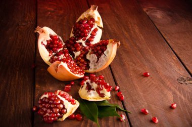 the pomegranate is ripe. cut into pieces of ripe pomegranate. on wooden boards. clipart