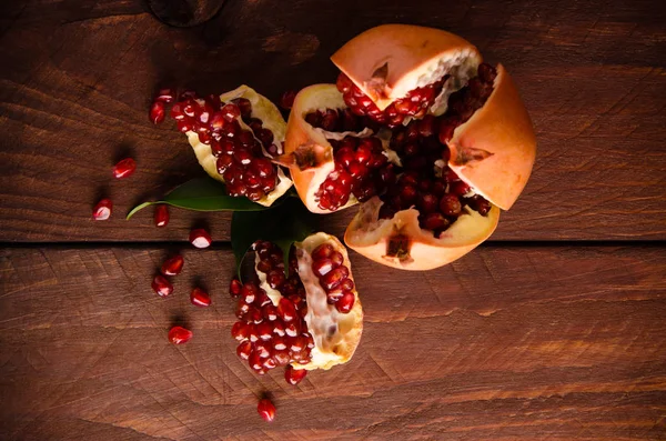 The pomegranate is ripe. cut into pieces of ripe pomegranate. on wooden boards. — Stock Photo, Image