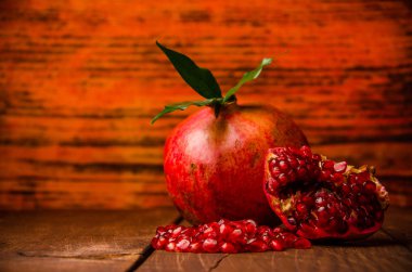 Olgun nar tohumları. Taze sulu yapraklar. Tahta tahtalar üzerinde sulu nar. Olgun nar parçalarına ayrılmış. Nar olgunlaştı..