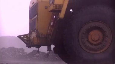 Taşlarla dolu büyük bir çöp kamyonu. BelAZ 'de. Yoğun sabah sisi