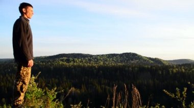 Adam kollarını açıp güneşin doğuşunu seyreder.