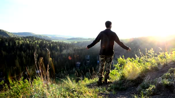 Mannen Står Med Sina Armar Utspridda Och Tittar Den Uppgående — Stockvideo