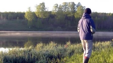 Bir adam sabah sisinin fotoğrafını çekiyor. Sıcak yaz manzarası.