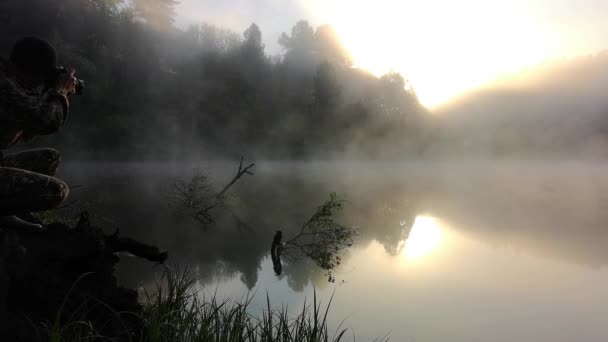 un homme photographie le brouillard du matin. Paysage d'été chaud .