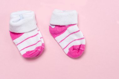 Pamuk pembe renkli bir arka plan üzerinde yeni doğan bebek çorap. Kopya alanı