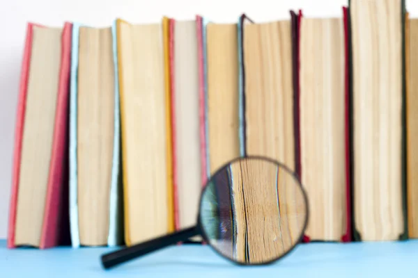 Açık kitap ve Büyüteç camı kompozisyonu. Okula dönüş, uzay kopyalayın. Eğitim arka plan.