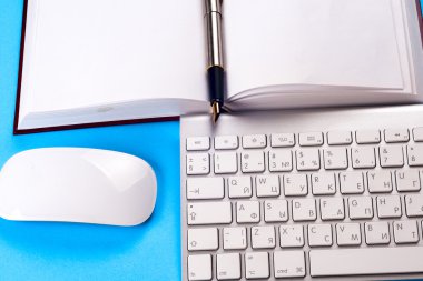 Ofis siyah resepsiyon masası beyaz bilgisayar, boş kartvizit, çiçek, kahve fincanı ve kalem.