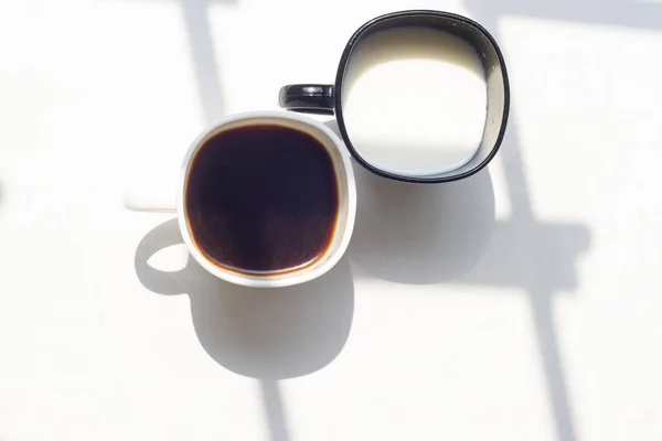 Hitam dan putih cangkir susu, kopi di latar belakang alam, top view — Stok Foto