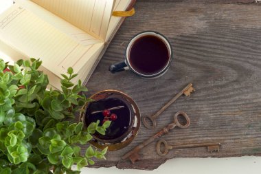 Eski kitaplar vintage, fincan çay, kek ve anahtarlar üzerinde rustik ahşap masa