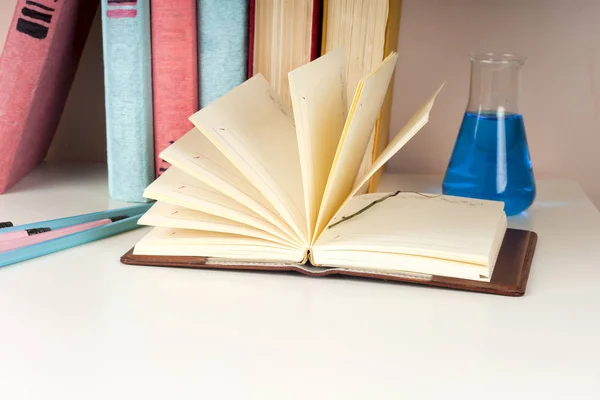 Offenes Buch, Stapel bunter gebundener Bücher auf hellem Tisch. zurück zur Schule. Kopierraum für Text — Stockfoto