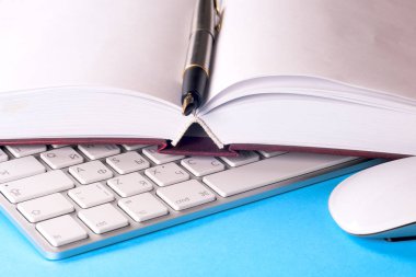 Ofis siyah resepsiyon masası beyaz bilgisayar, boş kartvizit, çiçek, kahve fincanı ve kalem.