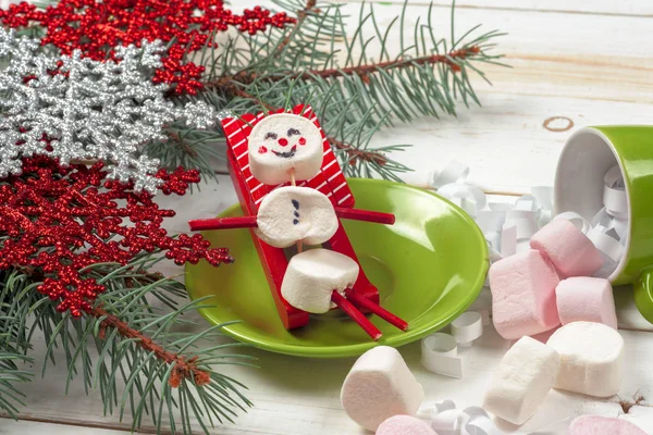 Weihnachtskarte mit lustigem Marshmallow-Schneemann in grüner Tasse, Baum — Stockfoto