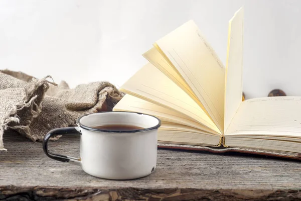 Oude vintage boeken, kopje thee, cake en toetsen op rustieke houten tafel — Stockfoto