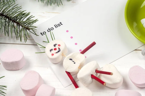 Weihnachtskarte mit lustigem Marshmallow-Schneemann in grüner Tasse, Baum — Stockfoto