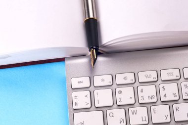 Ofis siyah resepsiyon masası beyaz bilgisayar, boş kartvizit, çiçek, kahve fincanı ve kalem.