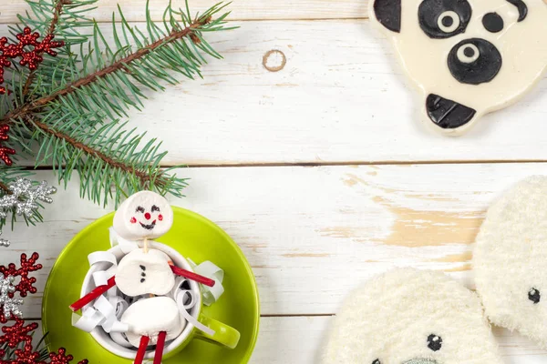 Weihnachtskarte mit lustigem Marshmallow-Schneemann in grüner Tasse, Baum — Stockfoto