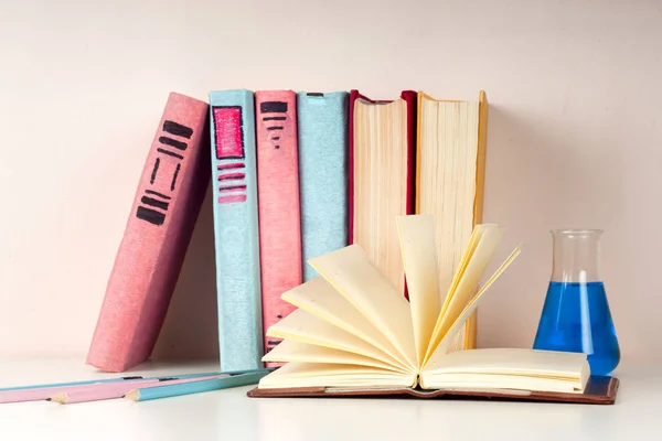 เปิดหนังสือกองหนังสือปกแข็งที่มีสีสันบนโต๊ะแสง กลับไปโรงเรียน คัดลอกพื้นที่สําหรับข้อความ — ภาพถ่ายสต็อก