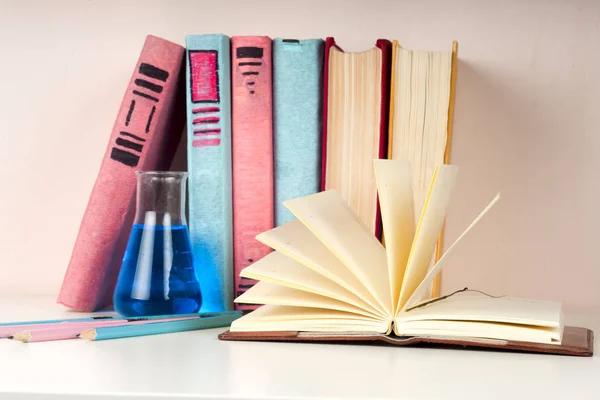 Libro abierto, pila de libros de tapa dura de colores en la mesa de luz. De vuelta a la escuela. Copiar espacio para texto — Foto de Stock